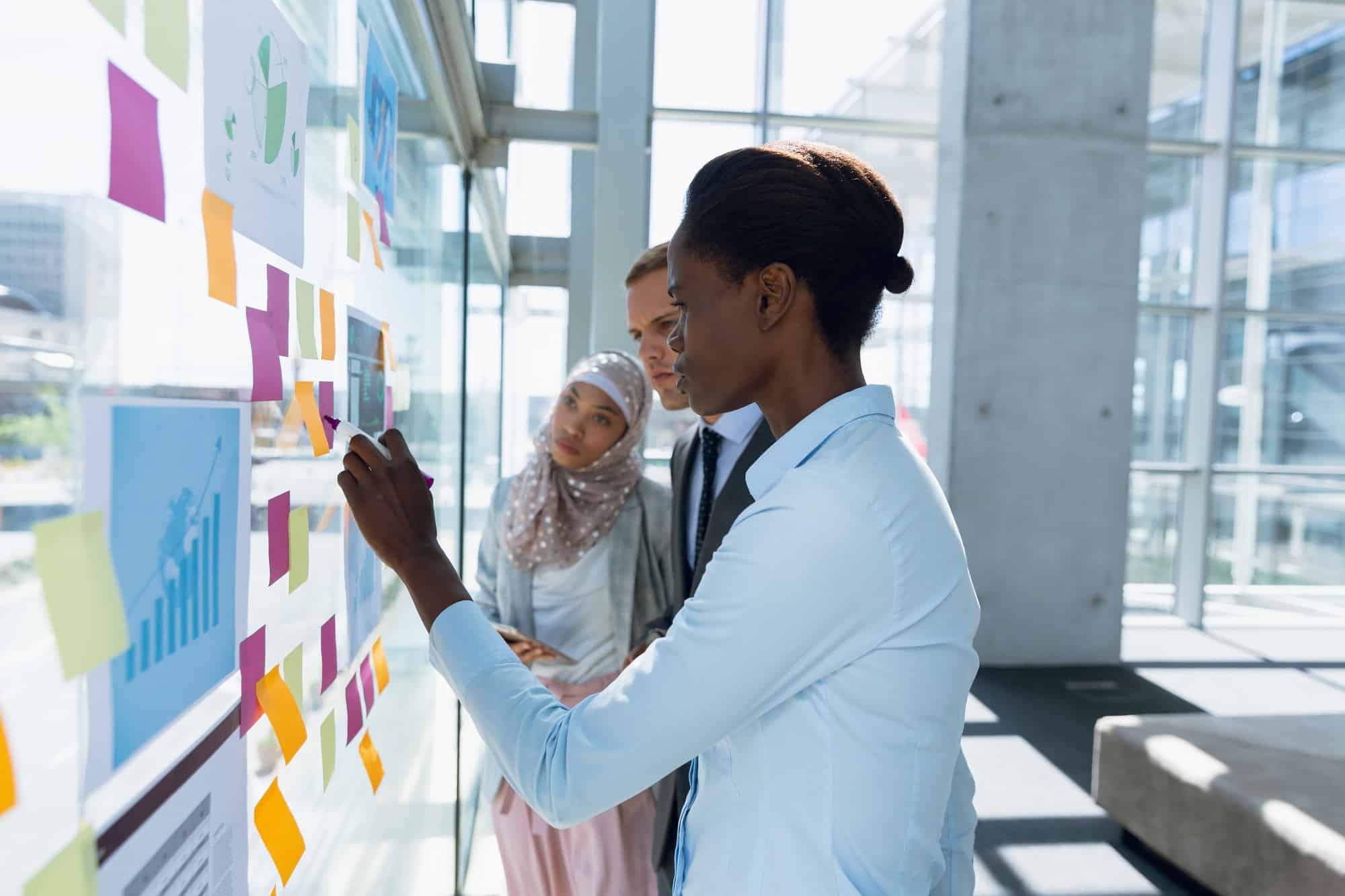 Business people discussing over sticky notes in office